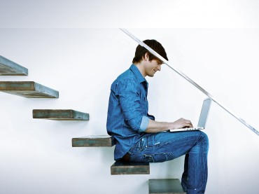 Self services man on stairs with laptop